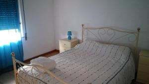 a white bed in a bedroom with a window at Casa das Lezírias in Unhais da Serra