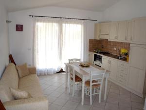 a living room with a couch and a table and a kitchen at CASADELFARO con Giardino a Pittulongu 600Metri dalla Spiaggia in Olbia