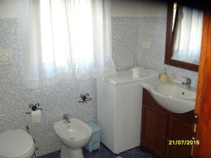 a bathroom with a sink and a toilet and a sink at CASADELFARO con Giardino a Pittulongu 600Metri dalla Spiaggia in Olbia +18 photos