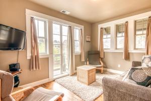 ein Wohnzimmer mit Fernseher und Fenstern in der Unterkunft Cascade Cottage in Lincoln City