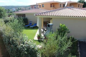 a house with a yard with chairs and a fence at CASADELFARO con Giardino a Pittulongu 600Metri dalla Spiaggia in Olbia