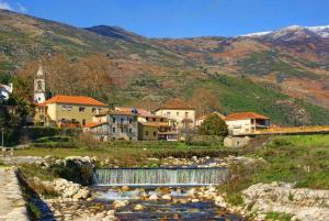 a small town with a river and a train at Casa das Lezírias in Unhais da Serra
