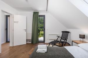 a bedroom with a bed and a chair and a window at Modern Alpine Monsalbius Chalet in Baške Oštarije