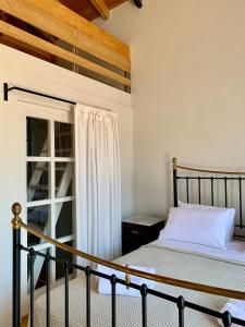 una camera da letto con un letto e una finestra di 1890 Fanourakis House a Calchi (Halki)
