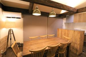 a dining room with a wooden table and chairs at スマートステイ大室山3合目 in Futo