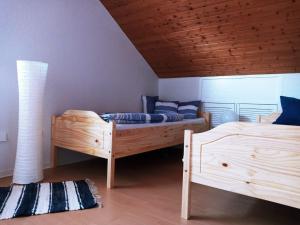 1 Schlafzimmer mit 2 Betten und Holzdecke in der Unterkunft Ferienwohnung am Lippesee in Paderborn