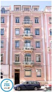 un edificio rosa con un coche aparcado delante de él en Hotel Dublin, en Lisboa