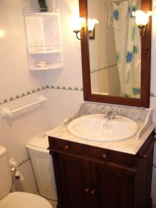 W łazience znajduje się umywalka, toaleta i lustro. w obiekcie ALMADRABA 1 w mieście Chiclana de la Frontera