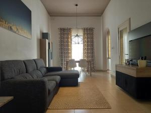 a living room with a couch and a television at Ayla Studio House in Birżebbuġa