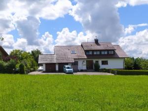 a house with a car parked in a yard at Ferienwohnung Trifts l Wallbox l Parkplatz l AusZeit Card in Wangen im Allgäu