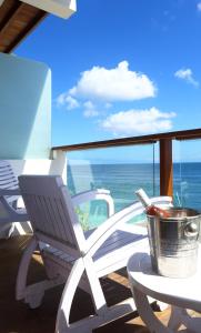 a white chair sitting on a balcony with the ocean at Bale Bingin Beachfront Stay in Uluwatu