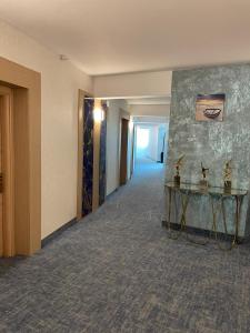 a hallway of a hotel with a table in the middle at Alcor Beach Hotel in Mamaia