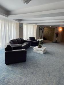 a living room with couches and a table at Alcor Beach Hotel in Mamaia