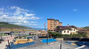 a building with a playground in front of the ocean at La Arena Beach sunset in Ciérvana
