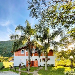 a house with palm trees in front of it at Ilha Náutica in Florianópolis