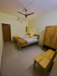 a bedroom with two beds and a ceiling fan at Thyme Guest House in Palolem