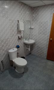 a bathroom with a toilet and a sink at Thyme Guest House in Palolem