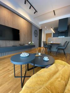 a living room with two tables and a couch at DOM Boutique Apartments PARK VIEW in Belgrade