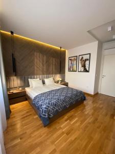a bedroom with a large bed and a wooden floor at DOM Boutique Apartments - Park View in Belgrade