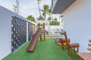 a balcony with a slide and chairs on a house at Quinta do Mar Flats Porto de Galinhas in Porto De Galinhas