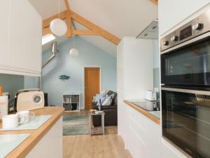 two views of a kitchen and a living room at Driftwood in Penzance