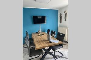 a dining room table with chairs and a blue wall at Ferienwohnung Moselgold in Piesport