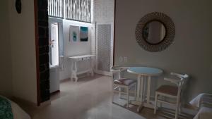 um quarto com uma mesa e cadeiras e um espelho em Pousada Marilia em Cabo Frio