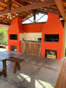 una cocina al aire libre con paredes de color naranja y una mesa. en Ilha Náutica, en Florianópolis