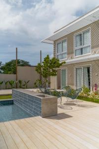a house with a swimming pool and chairs on a deck at Pousada Paraíso Noronha in Fernando de Noronha