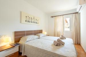 a bedroom with a bed with two towels on it at Apartment Almirall in Puerto Pollensa By homevillas360 in Pollença