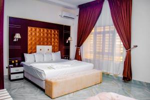 um quarto com uma cama grande e uma janela grande em CRISPAN SUITES & EVENT CENTRE em Jos
