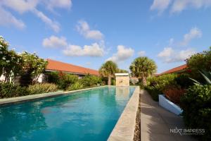 ein Swimmingpool mit blauem Wasser in einem Hof in der Unterkunft Ultimate Caribbean Experience in Willemstad