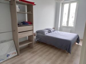 een kleine slaapkamer met een bed en een boekenplank bij agréable duplex Candé centre ville 4/6 places in Candé
