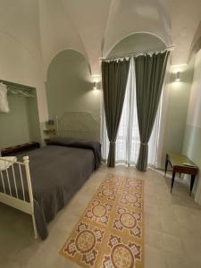 a bedroom with a bed and curtains and a rug at L'Armonia in Gaeta
