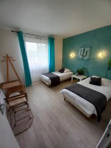 een hotelkamer met 2 bedden en een stoel bij Les Bruyeres in Plélan-le-Grand