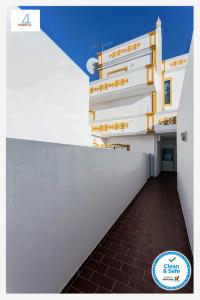 カバナス・デ・タビラにあるHOME4U - Cosy Apartment with Fantastic Terraceの白壁の建物につながる廊下