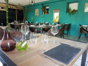 a table in a restaurant with wine glasses on it at Les Bruyeres in Plélan-le-Grand