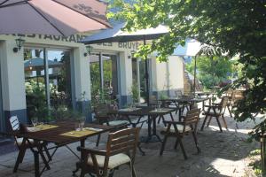 een rij tafels en stoelen buiten een restaurant bij Les Bruyeres in Plélan-le-Grand