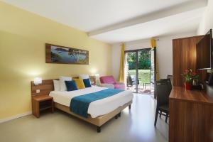 een hotelkamer met een bed, een bureau en een televisie bij Suite Home Aix en Provence Sud TGV in Bouc-Bel-Air