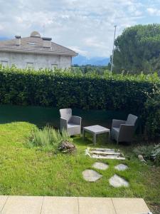 2 sillas y una mesa de centro en un patio en Tra natura e città - appartamento con giardino, en Costa Masnaga