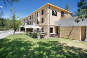 un bâtiment avec une pelouse devant lui dans l'établissement Suite Home Aix en Provence Sud TGV, à Bouc-Bel-Air