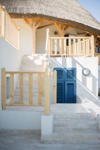 Casa de playa con techo de paja y escaleras en Pensiunea NEST, en Dunavăţu de Jos