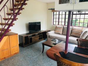 Twiga Hill Garden 5 في نيروبي: غرفة معيشة بها أريكة وتلفزيون