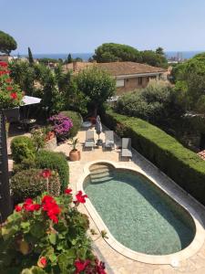 una piscina en un jardín con flores rojas en ARTS HOUSE - Cabrils, Maresme, Barcelona en Cabrils