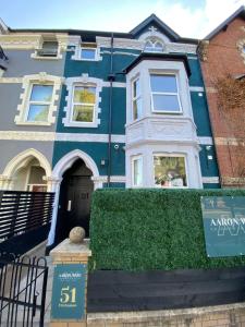 une maison bleue avec un panneau devant elle dans l'établissement Aaron Wise - 51 Fitzhamon Apartments, à Cardiff