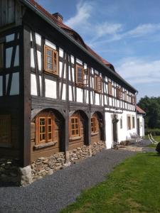 un edificio en blanco y negro con ventanas y césped en Izerski dom, en Leśna