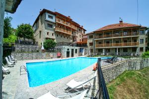 a swimming pool in front of a building at Hotel Victoria in Metsovo