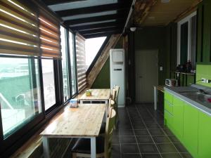 a kitchen with a wooden table and a large window at Jeonju International Hostel in Jeonju