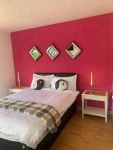 a bedroom with a red wall and a bed with pillows at Hillcrest House Self Catering Apartments in Donegal