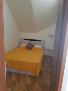 a small bedroom with a yellow bed in a room at CarolMike Oasis Beach Apartment Kamchia Reserve in Kamchia